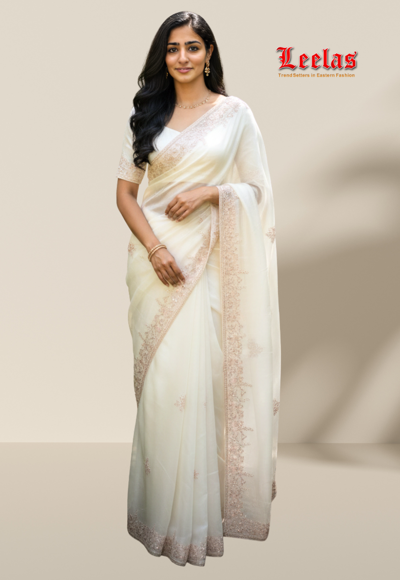 Off white tissue silk saree with stone work bead work and gold and pink sequins work border.