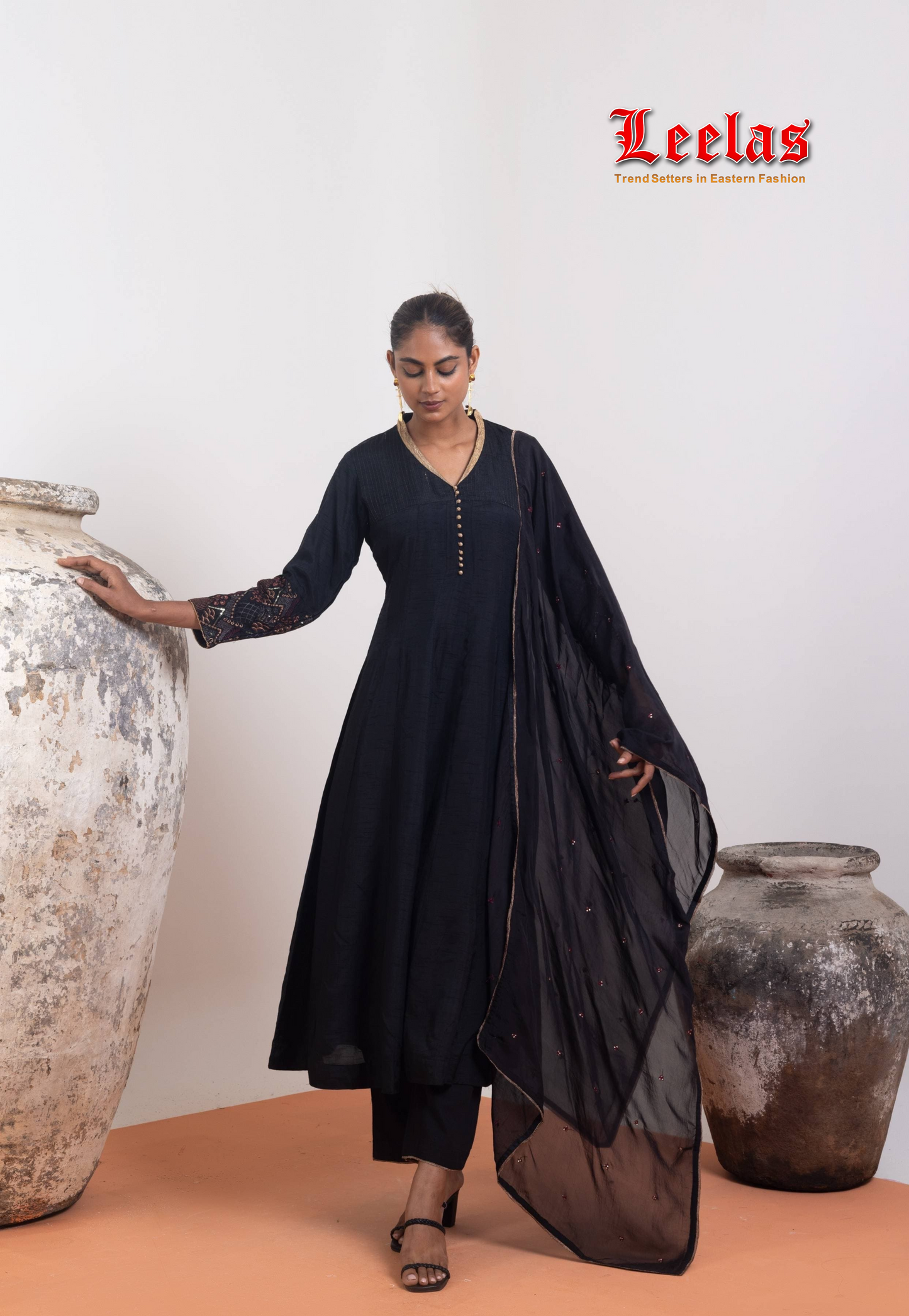 Black and gold silk salwar kameez with gold trim on neckline and gold button detail
