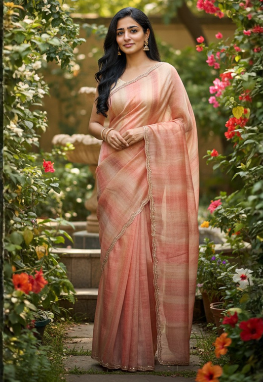 Stylish ombre tissue silk saree featuring a gradient blend of beige, red and gold tones, adorned with a delicate scalloped stonework border