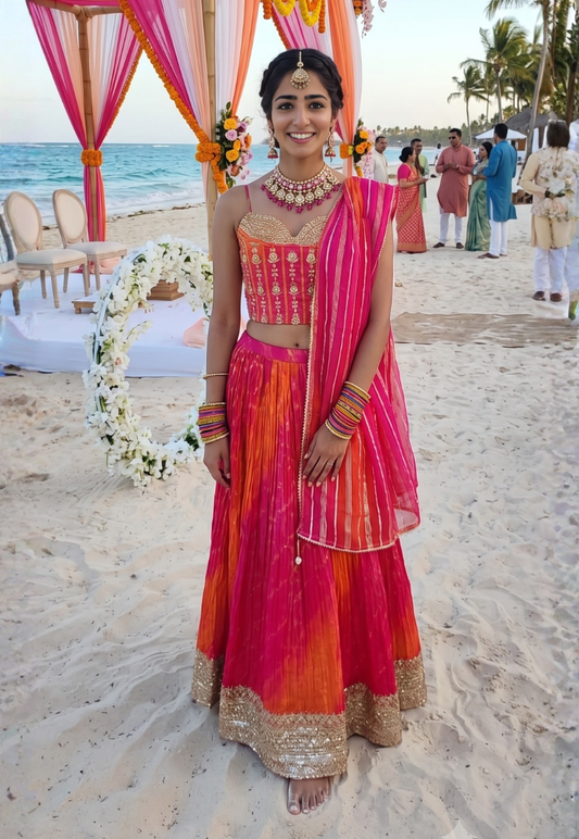 Vibrant pink and orange ombre shaded lengha with gold gotapatti and sequins corset style top