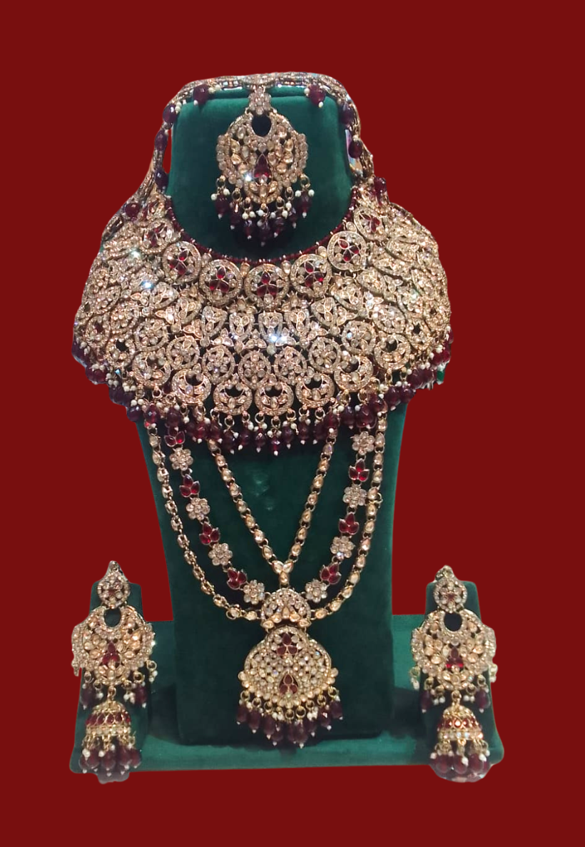 Traditional bridal jewellery set featuring kundan work with red stones and gold plating finishes