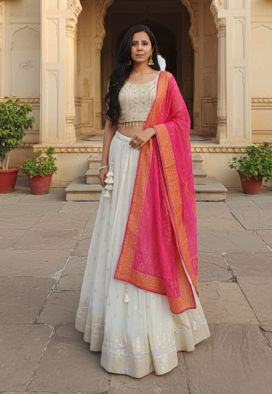 Off white stitched georgette lengha with intricate embroidery, sequins and mirror work with traditional bandhani style dupatta.